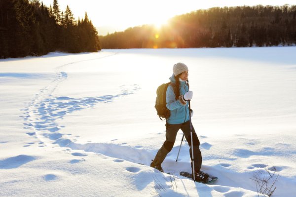 Frau beim Schneeschuhwandern an einem sonnigen Tag