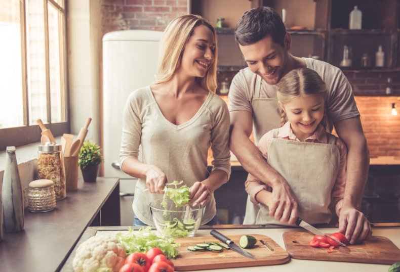 Vater, Mutter und Kind schneiden gemeinsam Gem&uuml;se