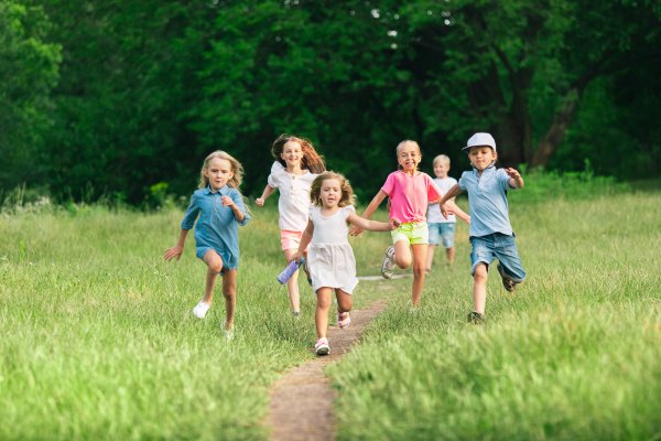 Kinder stehen im Kreis und schauen nach unten im Licht der Sonne