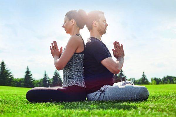 Homme et femme assis en tailleur dans la nature