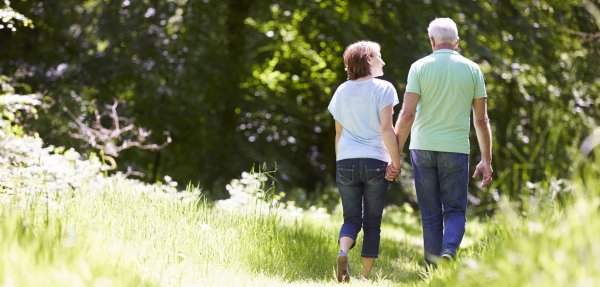 Eine Frau spaziert mit ihrem Mann durch den Wald