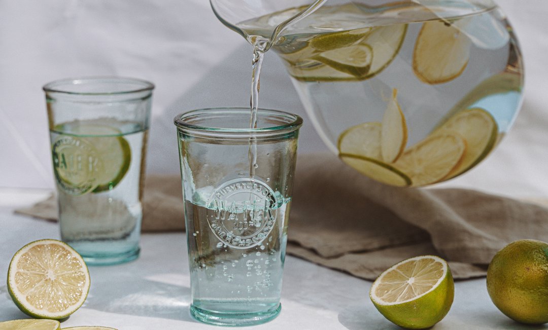 Wassergläser und Karaffe mit Limetten